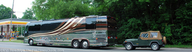 An RV motorhome towing a Jeep Wrangler with four wheels down. rv-motorhome-towing-jeep-wrangler-four-wheels-down.jpg