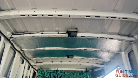 Insulation placed between the ceiling cross-ribs on a cargo van.