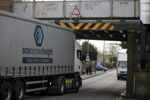 A truck going under a low bridge.