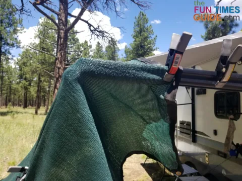 Sun shade clamped to the RV awning rail.